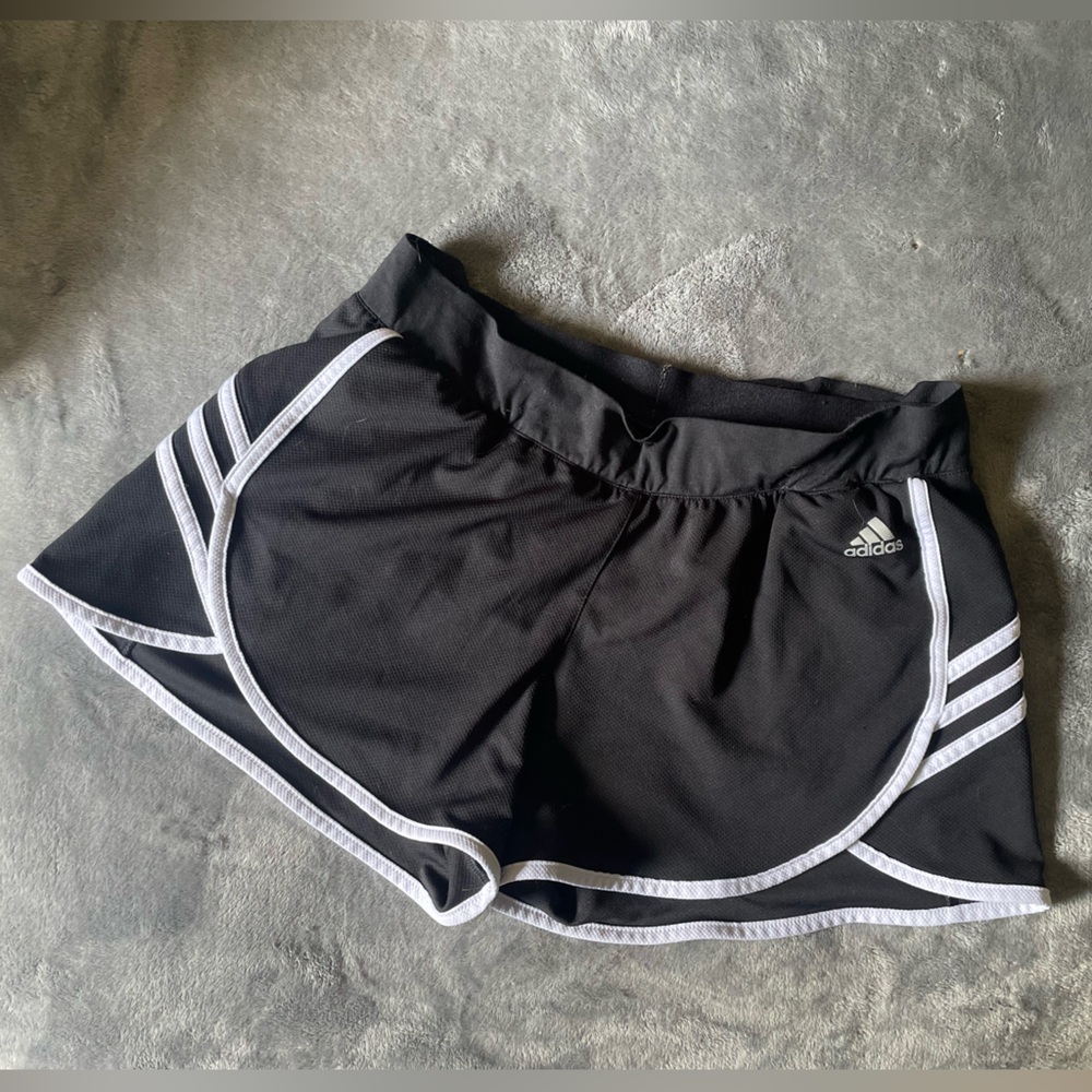 Medium black adidas shorts with white stripes.